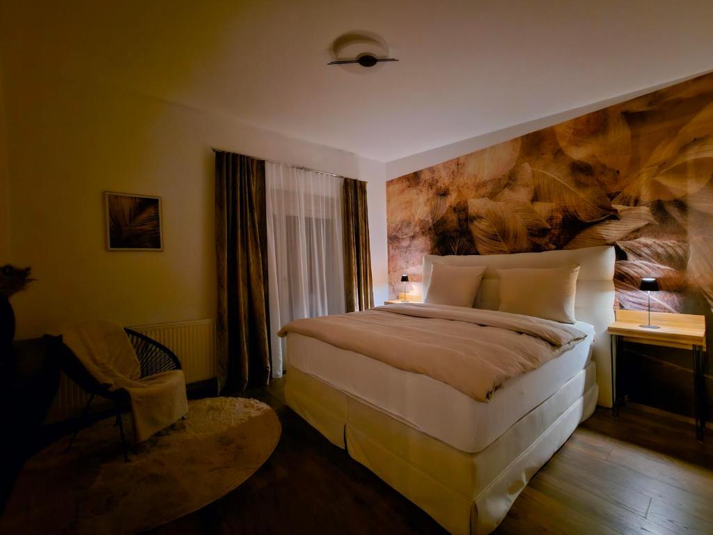 een slaapkamer met een groot bed met een schilderij aan de muur bij Ferienwohnung Blick ins Grüne in Rossleithen