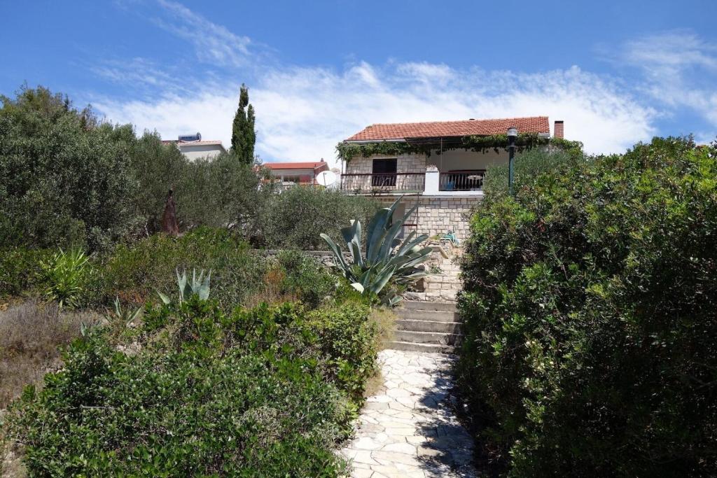 une maison sur une colline avec un chemin menant à celle-ci dans l'établissement Apartments Nev, à Blato