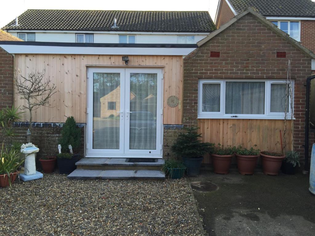 a front door of a house with potted plants at Lark Rise B&B in Wangford