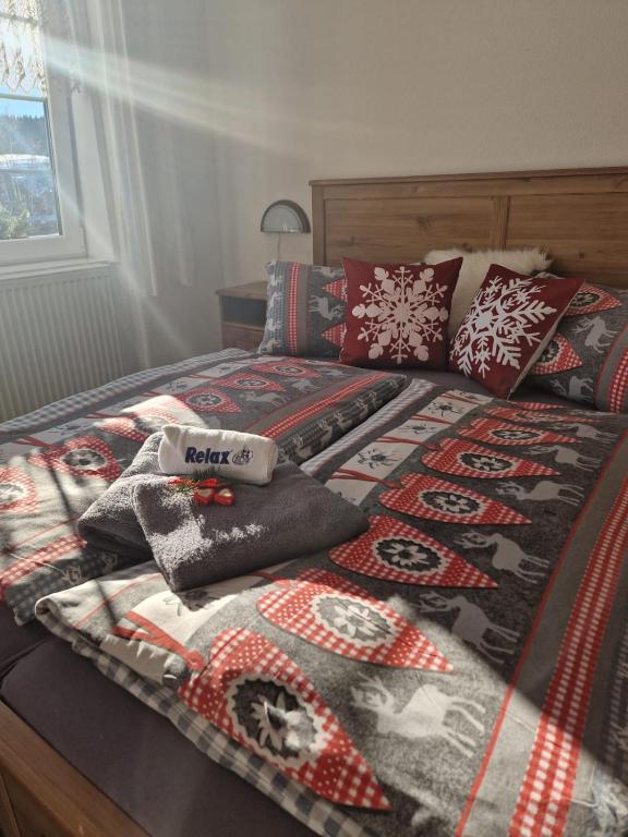 a bed with a comforter and pillows on it at Pension MAX in Pernink
