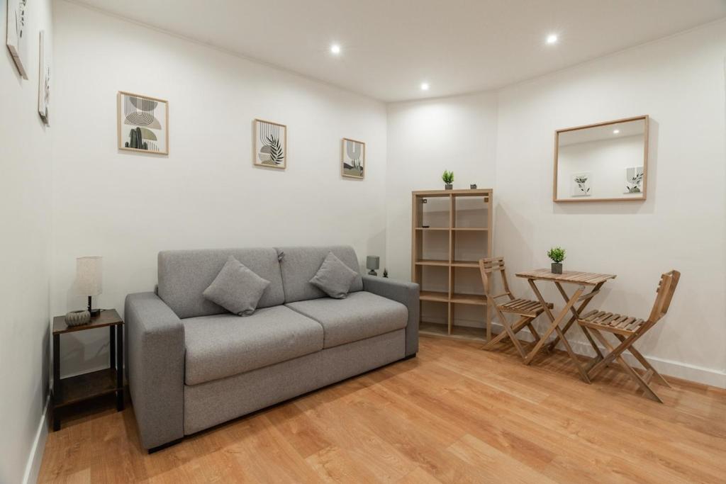 un salon avec un canapé et une table dans l'établissement Charming Studio near Sacré-Coeur, à Paris