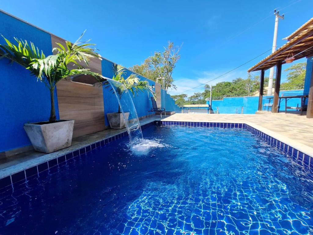 a swimming pool with a fountain in the middle at Linda Casa Linear Com PISCINA, Buzios in Buzios