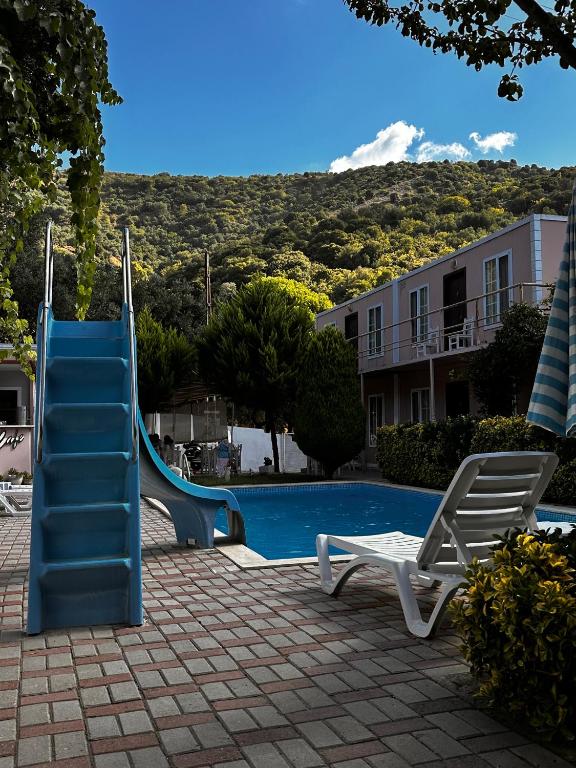 a blue slide next to a swimming pool at Ali Baba Butik Otel in Gündoğdu
