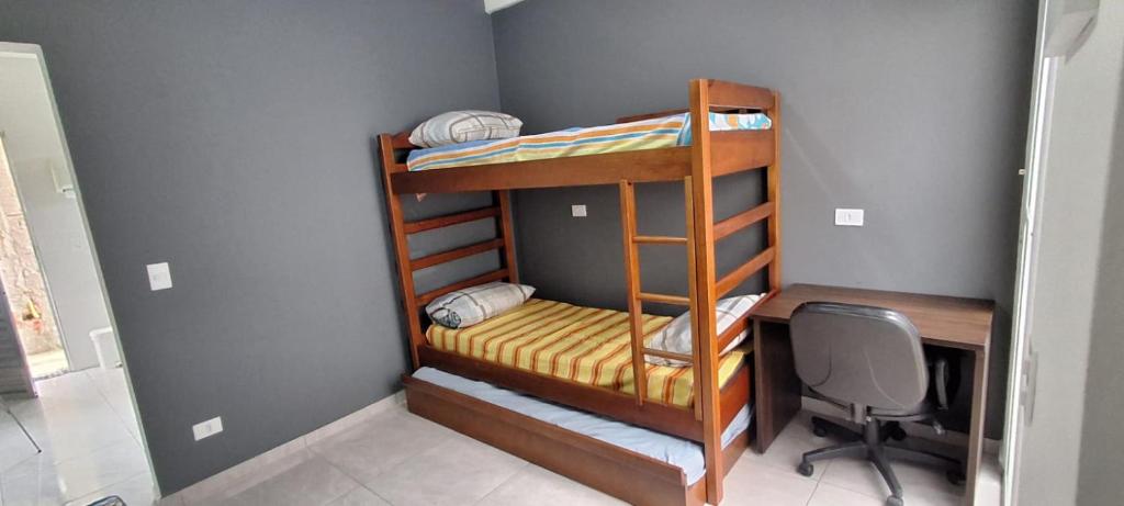a room with two bunk beds and a desk at Araçariguama in Araçariguama