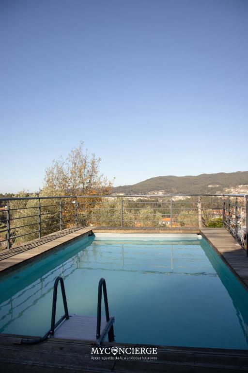 a large swimming pool with blue water at Quinta Do Larai in Vale de Cambra