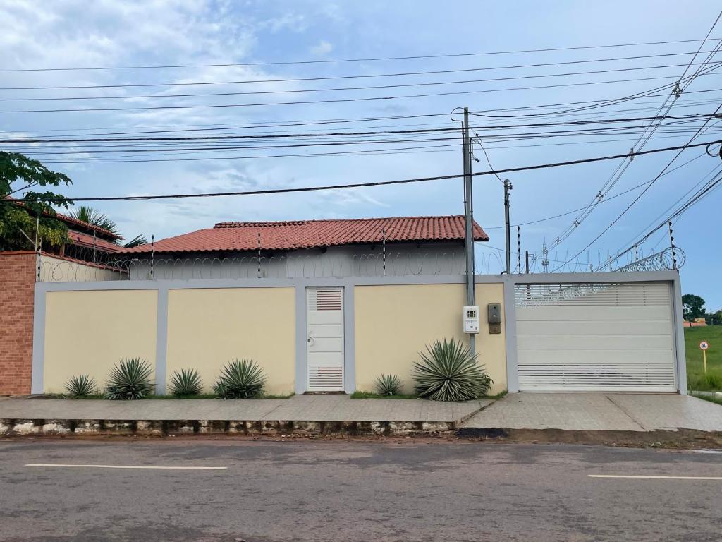 un edificio con due porte garage e alcune piante di Casa a Rio Branco