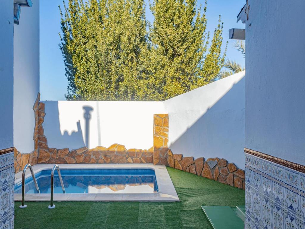 a swimming pool in a house with a stone wall at Country House Cuevas Bajas by Genil River in Cuevas Bajas