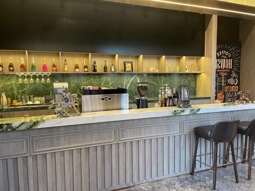 a bar with two chairs and a counter with wine bottles at Tianyongge Art Hotel Shanghai Disney Store in Shanghai