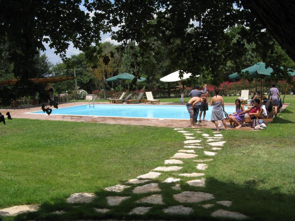 a group of people standing in a park near a swimming pool at Villaggio Del Sole in Giove