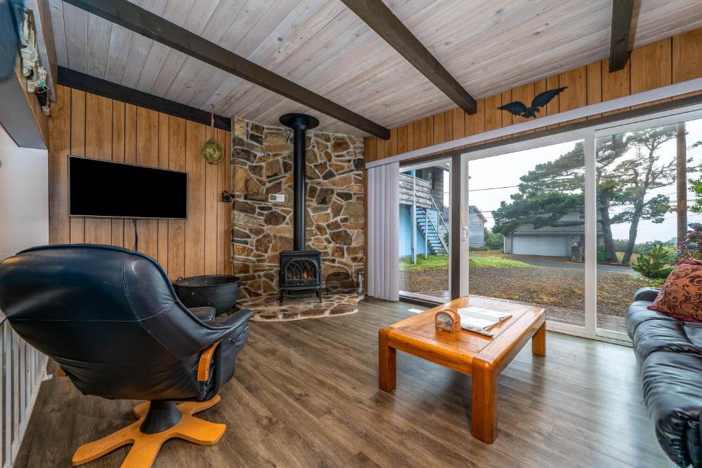 a living room with a chair and a fireplace at Woodley Beach House in Lincoln Beach