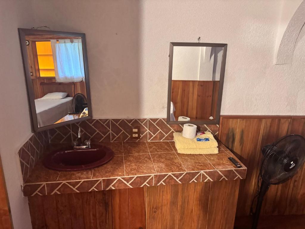 un bagno con lavandino e specchio di Posada Quetzalin a Cuetzalan del Progreso
