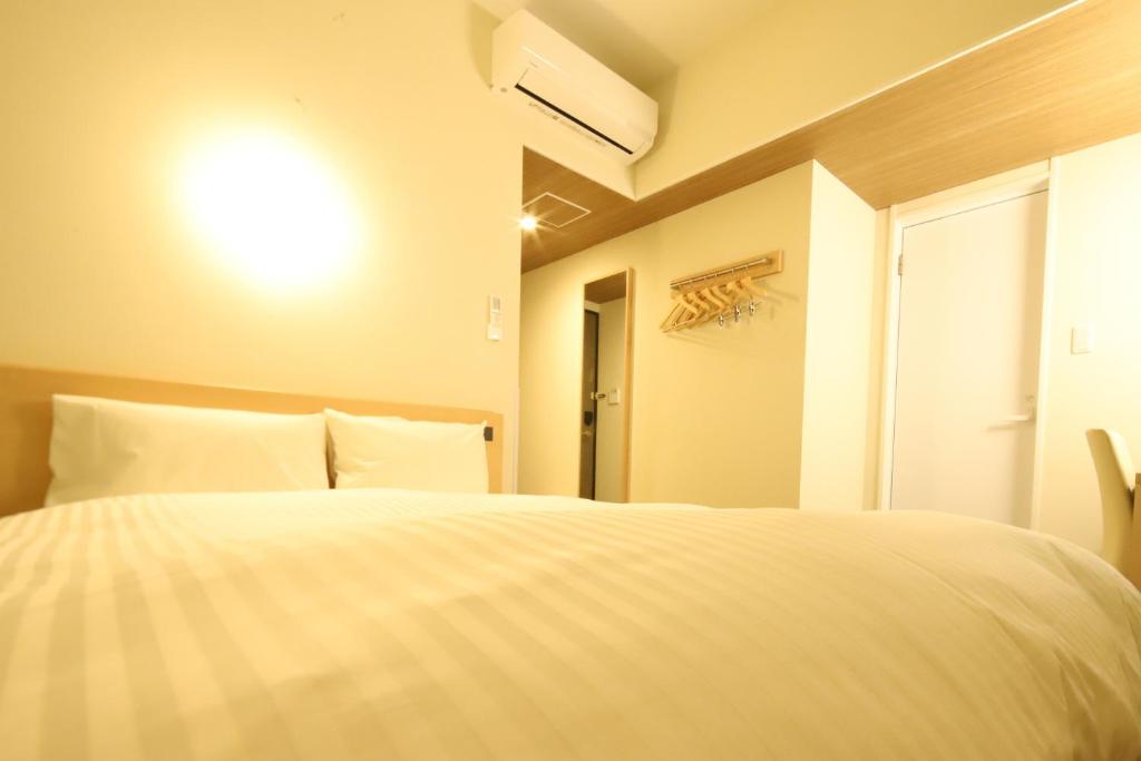 Postel nebo postele na pokoji v ubytování AB Hotel Nakatsugawa