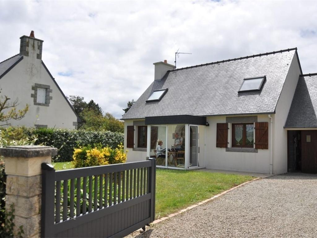 une maison blanche avec une clôture devant dans l'établissement Maison cosy à 250m de la plage de Pors Gelen avec jardin et parking - FR-1-368-446, à Pleumeur-Bodou