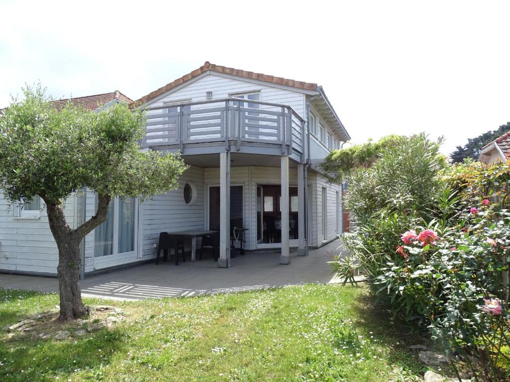 Cette maison blanche dispose d'une terrasse couverte et d'un balcon. dans l'établissement Maison éco près de la mer avec jardin et wifi - FR-1-306-1291, à Pornic