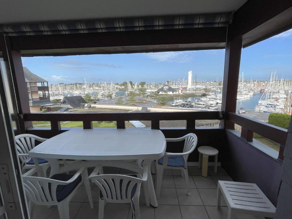 d'une table et de chaises sur un balcon avec vue sur le port. dans l'établissement Confortable appartement 4 pers. avec terrasse, piscine et parking à Arzon - FR-1-775-8, à Arzon