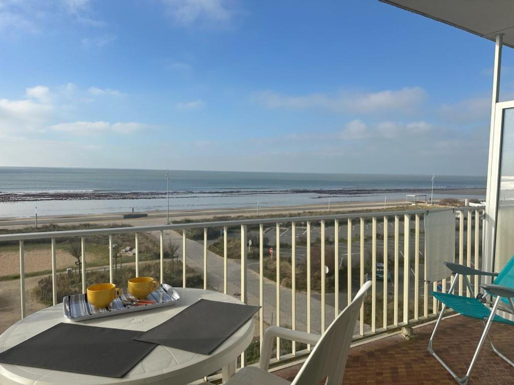 d'un balcon avec une table et une vue sur la plage. dans l'établissement Studio face à la mer pour 4, parking, balcon - Notre-Dame-de-Monts - FR-1-540-310, à Notre-Dame-de-Monts