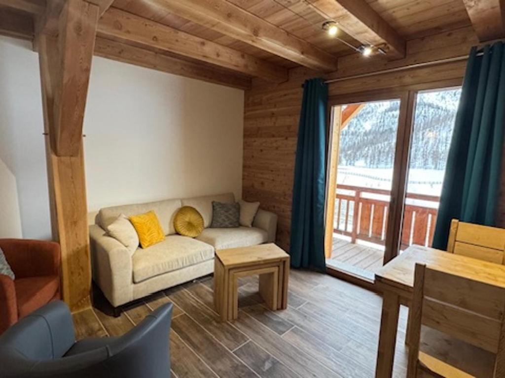 un salon avec un canapé et une grande fenêtre dans l'établissement Superbe duplex montagnard luxe pour 6 pers. à Montgenèvre - FR-1-445-214, à Montgenèvre