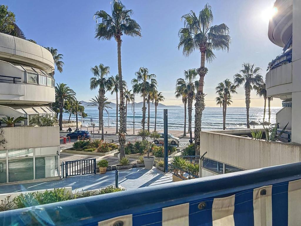 une vue sur une plage avec des palmiers et l'océan dans l'établissement Appart. Vue Mer, Climatisé & WiFi à La Ciotat - FR-1-770-41, à La Ciotat