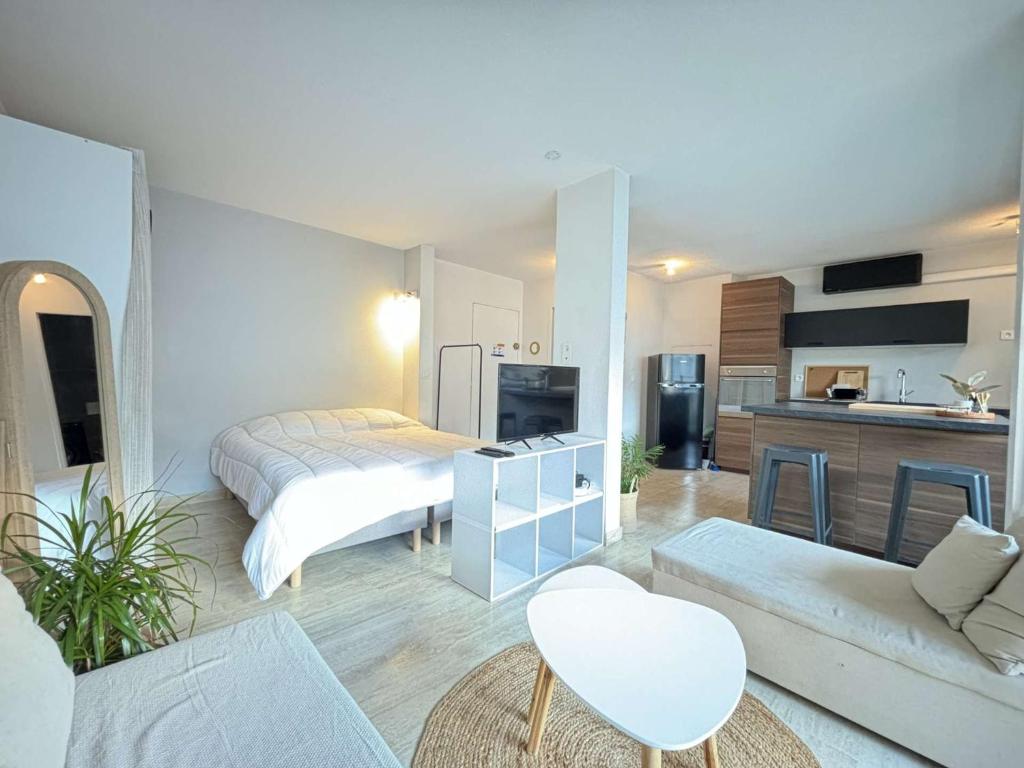 un salon avec un lit et une cuisine dans l'établissement Studio moderne avec terrasse sur le toit, parking et WIFI - FR-1-226B-225, à Cavalaire-sur-Mer