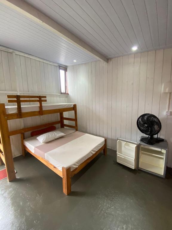 a bedroom with a wooden bed in a room at Estudio Aconchegante no Sul da Ilha in Florianópolis