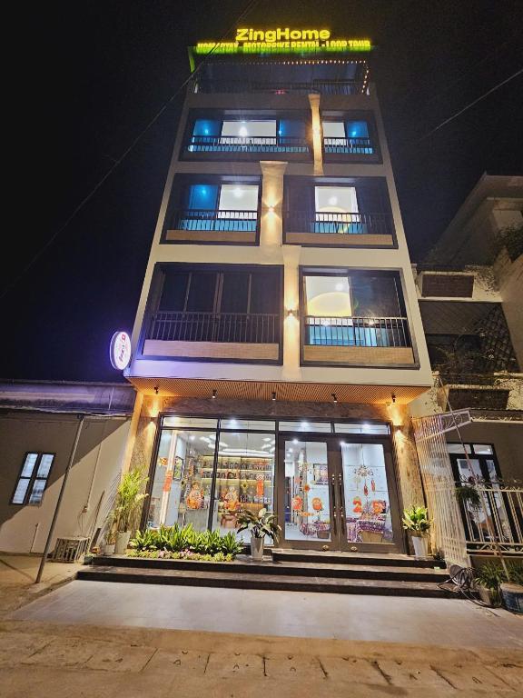 a tall building with a store front at night at ZingHome Hà Giang in Ha Giang