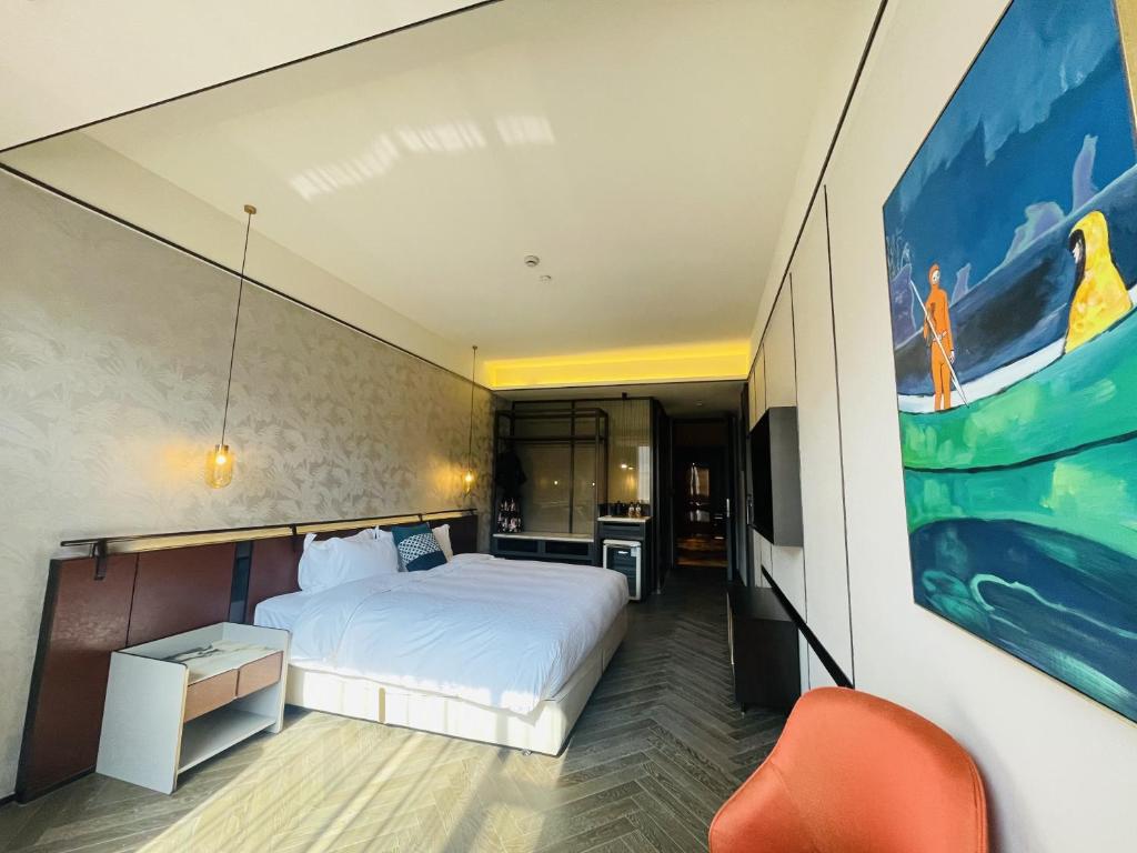 a bedroom with a bed and a painting on the wall at Tianyongge Art Hotel Shanghai Disney Store in Shanghai