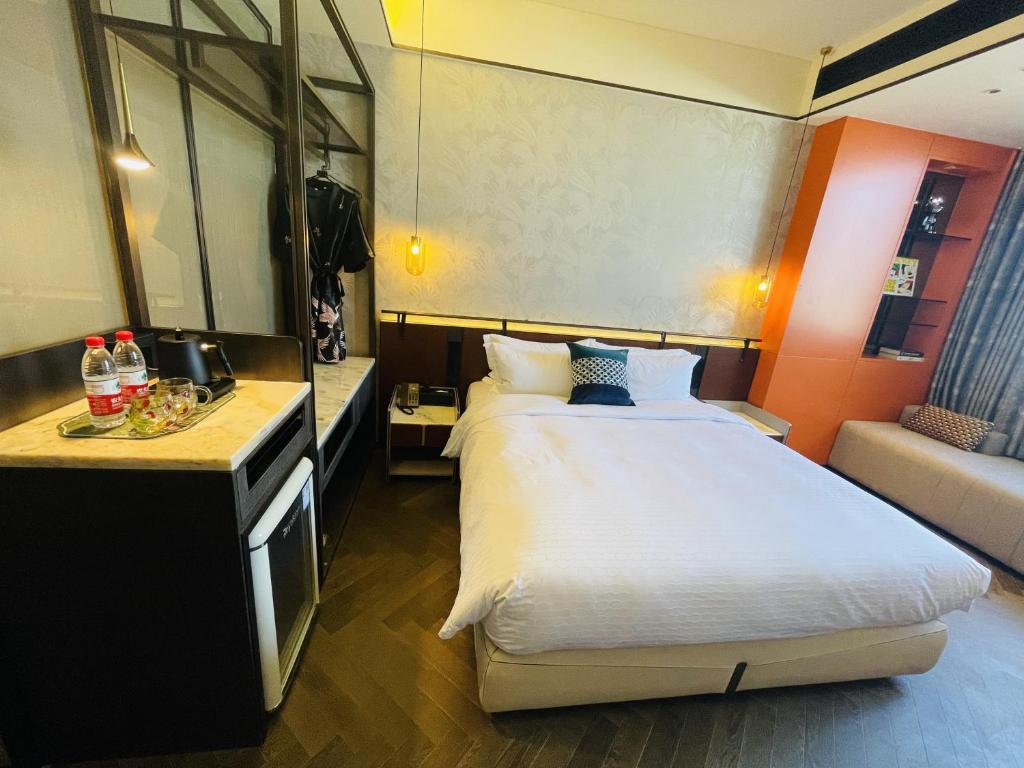 a hotel room with a large bed and a kitchen at Tianyongge Art Hotel Shanghai Disney Store in Shanghai