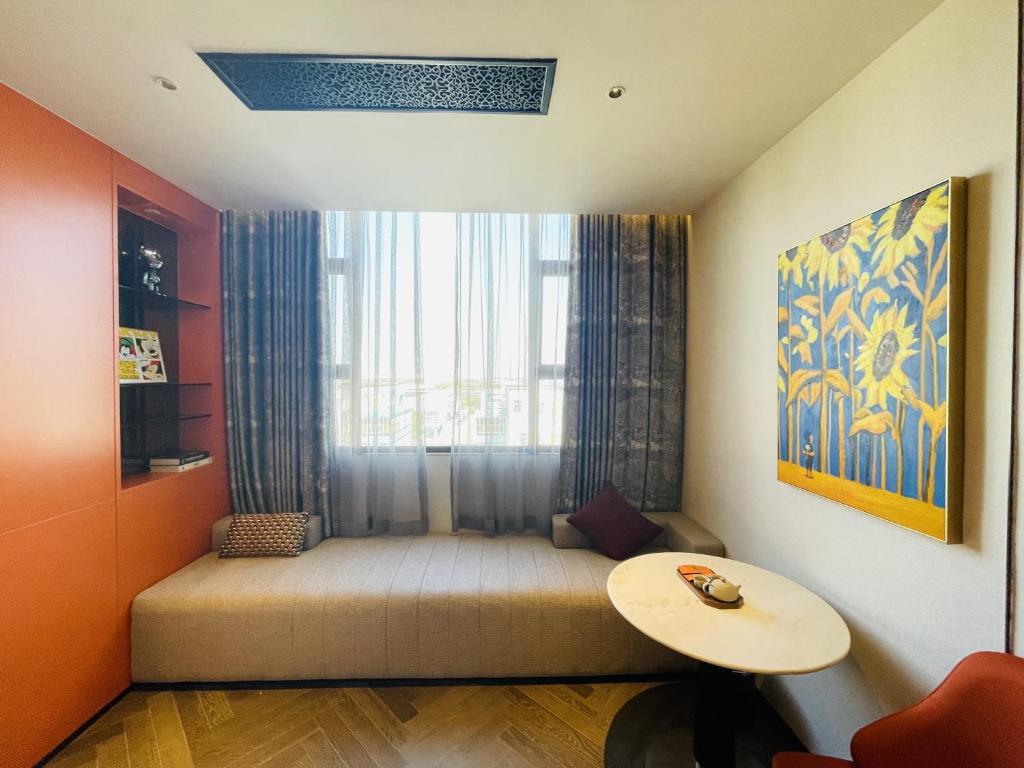 a small room with a couch with a window at Tianyongge Art Hotel Shanghai Disney Store in Shanghai