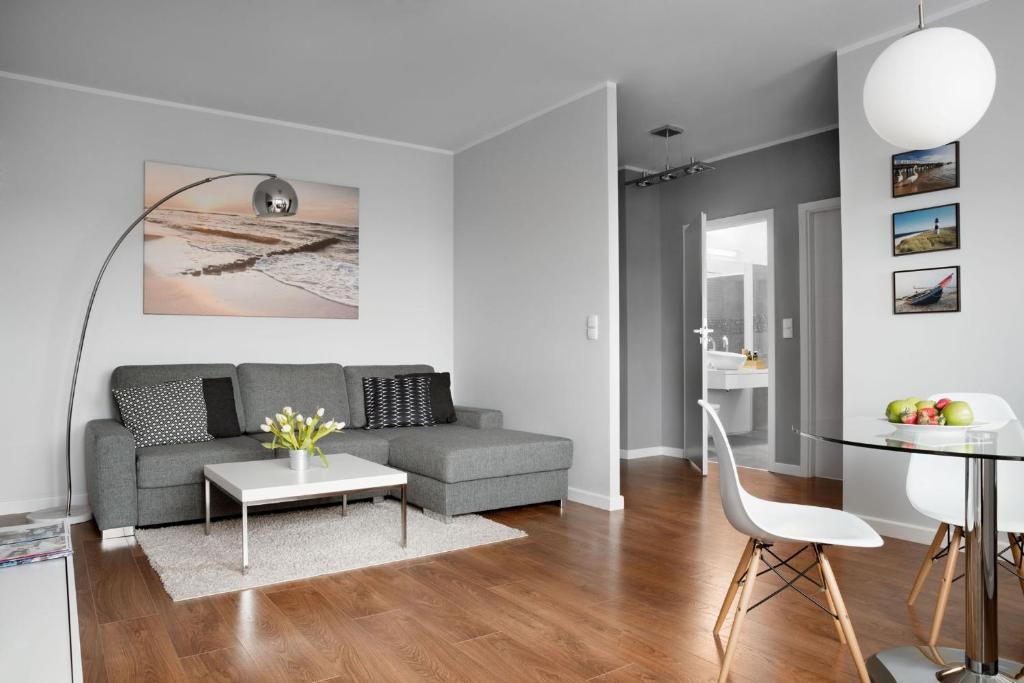 uma sala de estar com um sofá e uma mesa em IRS ROYAL APARTMENTS Apartamenty IRS Aviator em Gdansk