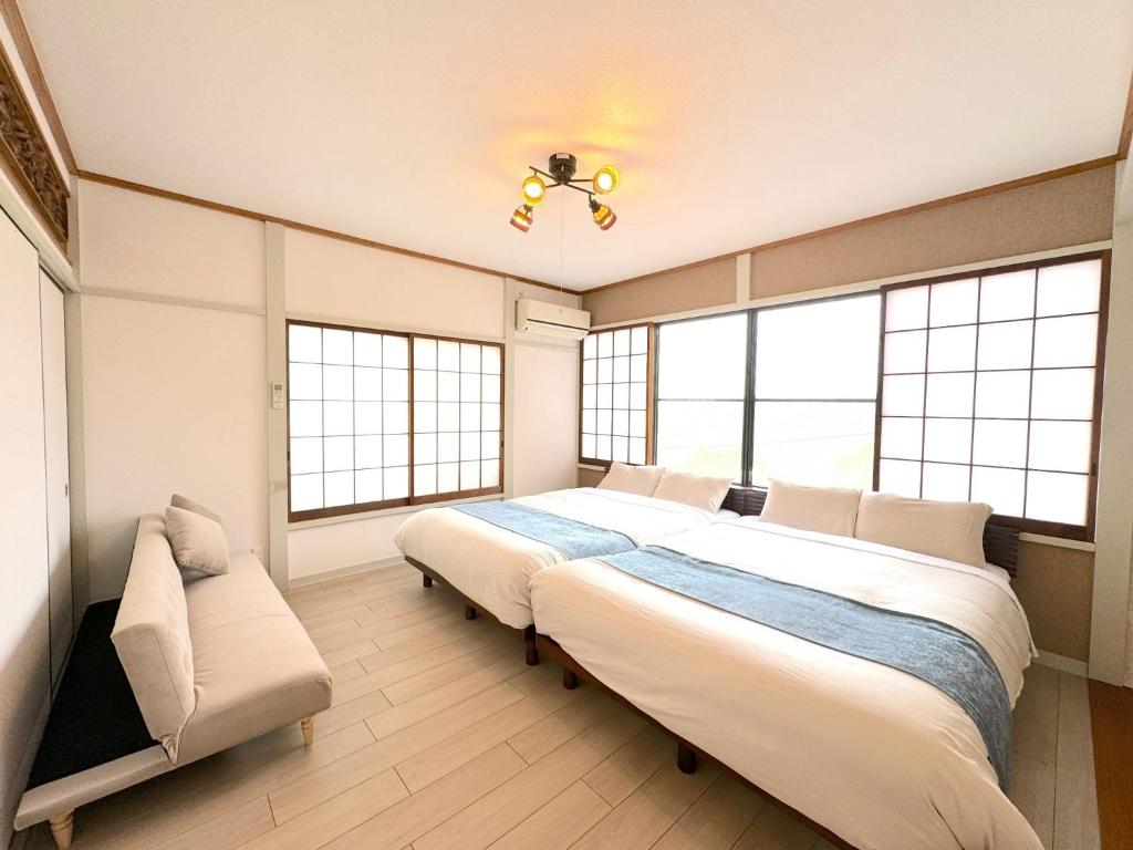 a bedroom with two beds and a couch and windows at Ashigarashimogun - House - Vacation STAY 17328 in Miyakami