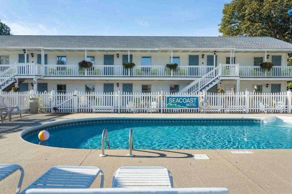a hotel with a swimming pool in front of a building at Seacoast Motel in Wells