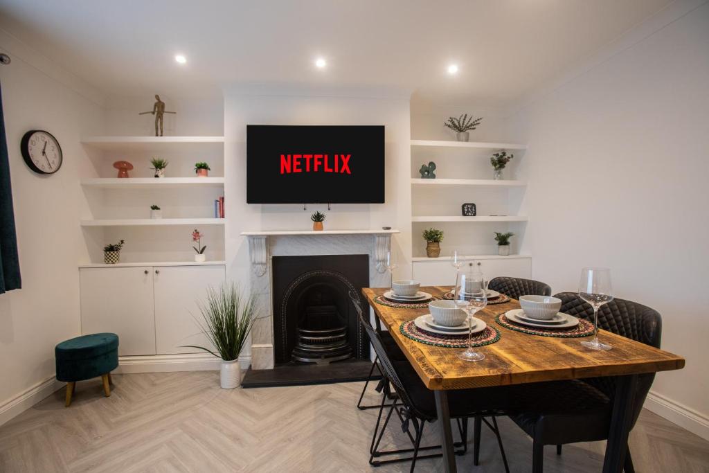 a living room with a table and a tv above a fireplace at Modern Bromley 2 Bed apartment great location parking available in Grove Park