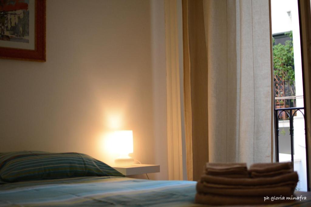 1 dormitorio con cama y lámpara junto a una ventana en I Pupi Di Belfiore, en Palermo