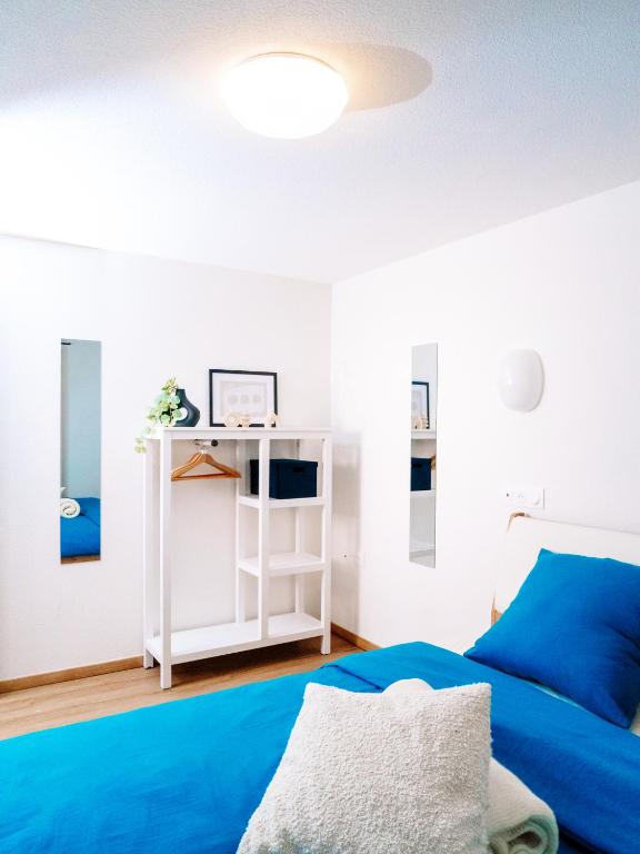 - une chambre avec un lit bleu et une étagère blanche dans l'établissement La Suite Cosy, à Roppenheim