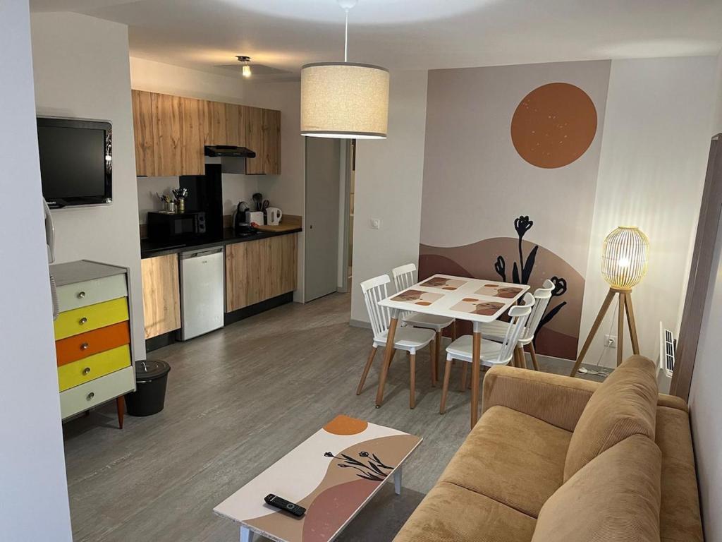 un salon et une cuisine avec un canapé et une table dans l'établissement Charmant T2 Via Rhôna - 4 min St Vallier, à Ponsas