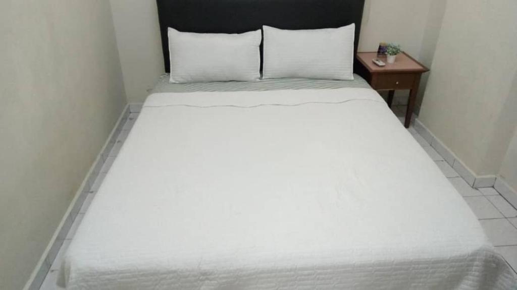 a large white bed in a small room at Ground floor apartment Seaview beach in Port Dickson