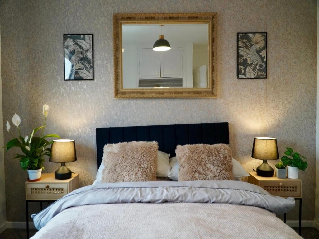 a bedroom with a bed with a mirror and two lamps at Deal House in Stockton-on-Tees