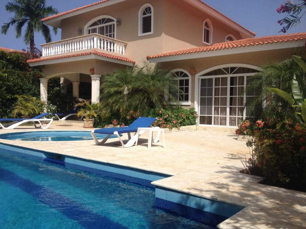 a villa with a swimming pool and a house at Villa Sosua Hispaniola Residencial in Sosúa