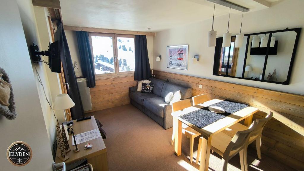 un petit salon avec une table et un canapé dans l'établissement Appartement Les Gémeaux - La Plagne - Belle Plagne, à La Plagne Tarentaise