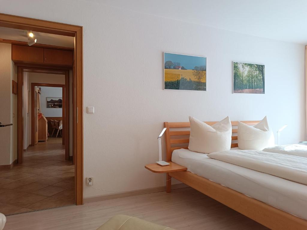 费斯恩4-Raum FeWo Silberdistel - Hallenbad & Sauna的一间卧室，配有一张床和一张带电视的桌子