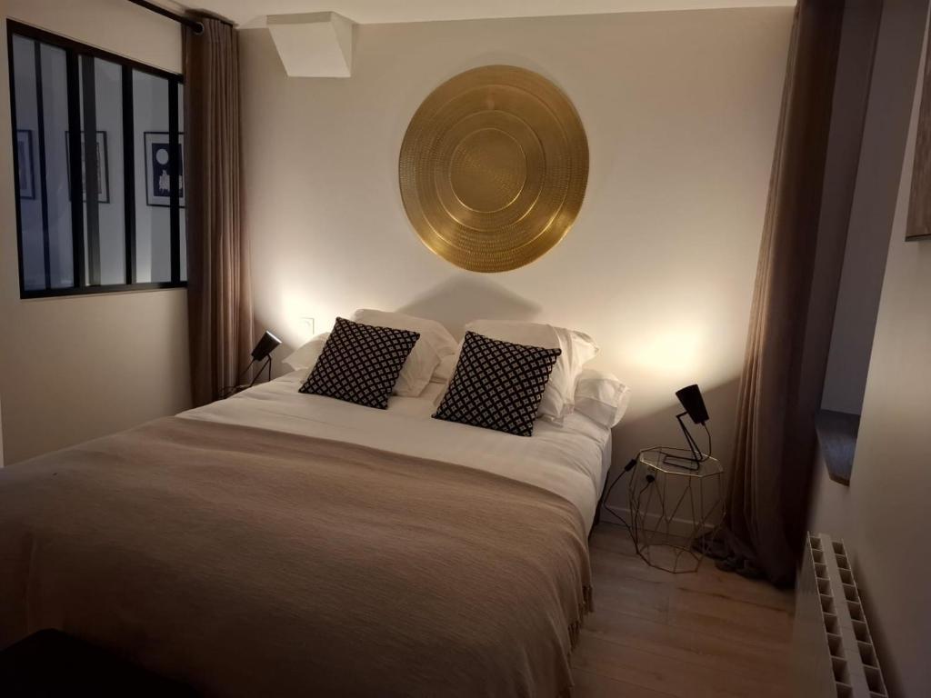 a bedroom with a large bed with two pillows at Joli appartement au coeur de Mâcon in Mâcon