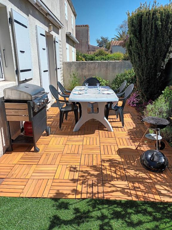 d'une terrasse avec un grill, une table et des chaises. dans l'établissement Le clos de la Galiote, à Saint-Pierre-dʼOléron