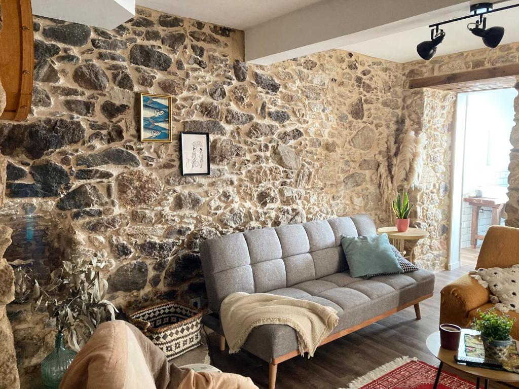 a living room with a stone wall with a couch at Apartamento en Casa Oliveros, Razo in A Coruña