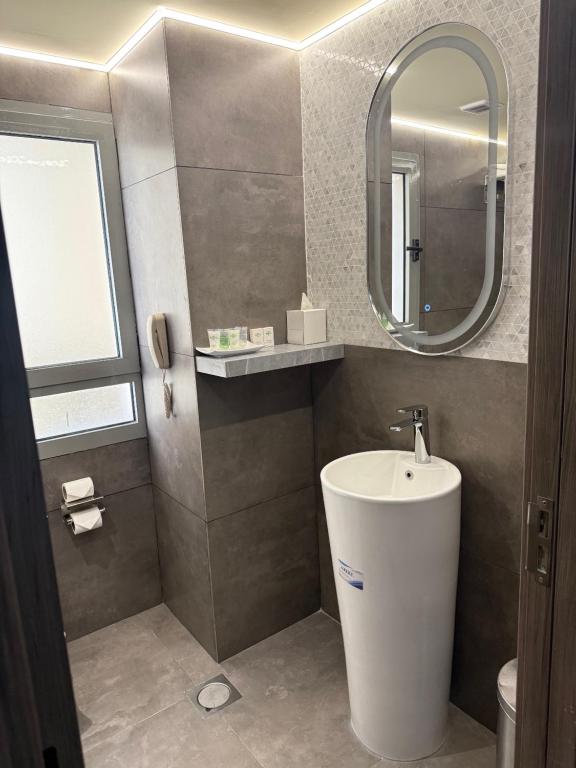 a bathroom with a sink and a mirror at Strand Hotel in Abu Dhabi