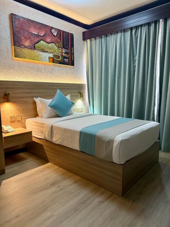 a bedroom with a large bed with a window at Strand Hotel in Abu Dhabi