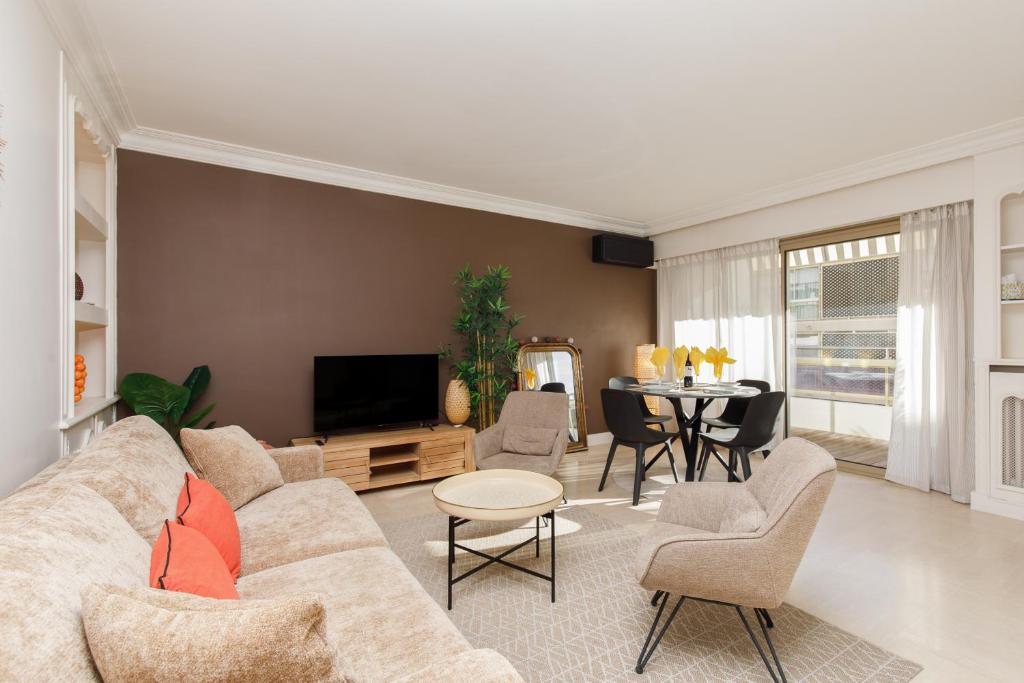 un salon avec un canapé et une table dans l'établissement Le Palais Royal Elégant Confortable -Balcon 100 mètres Croisette, à Cannes