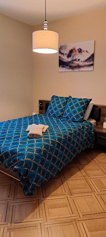 - un lit avec une couette bleue dans une chambre dans l'établissement L'Arbre Rose de Bergheim, à Bergheim