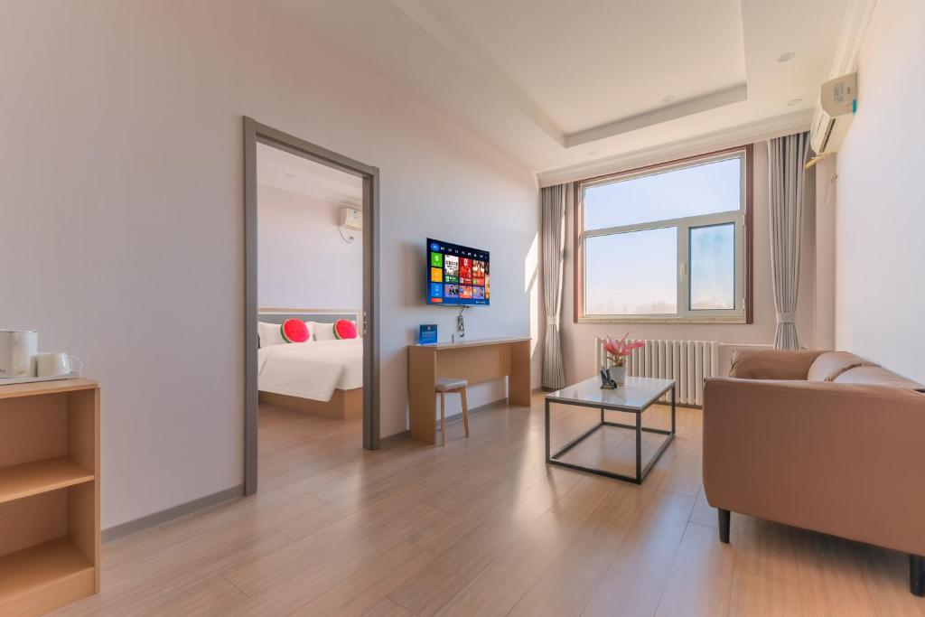 北京市にあるBeijing Watermelon Journey Hotel - Daxing Airportのソファとベッドのあるリビングルーム
