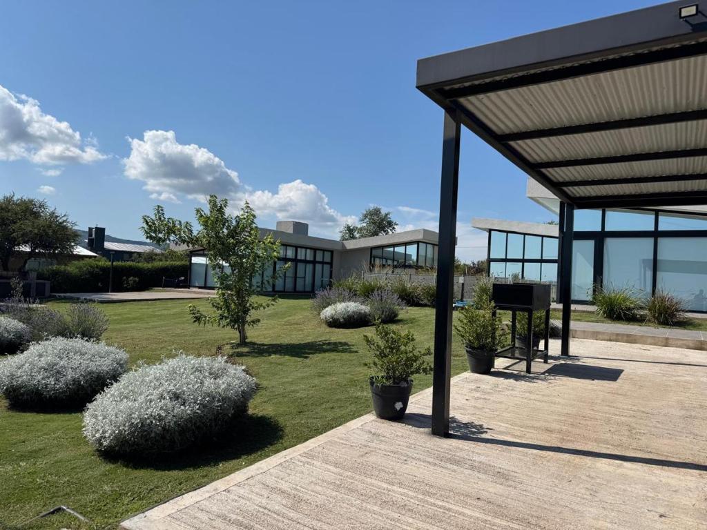 a building with a pavilion with plants in a yard at Olivos del Solar in Villa General Belgrano