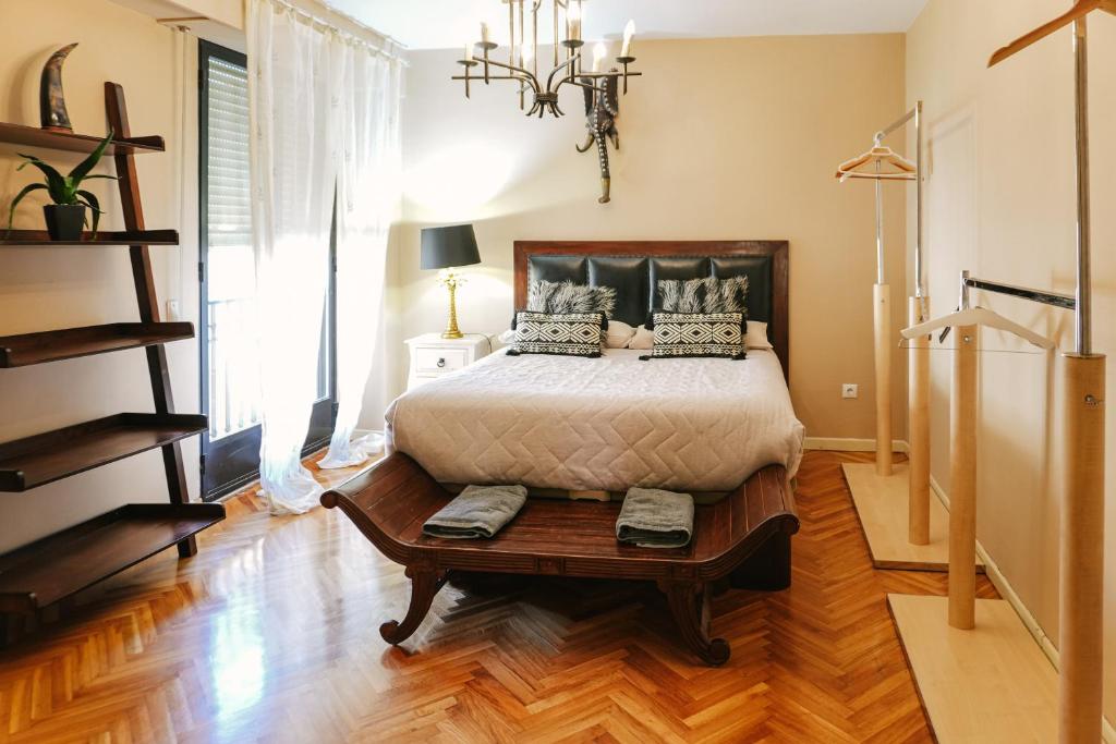 a bedroom with a bed and a wooden floor at Apartamento plaza Mayor Húmedo con parking incluido in León